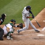 OAKLAND, CALIFORNIA - SEPTEMBER 26: Evan White #12 of the Seattle Mariners hits a single that scored a run against the Oakland Athletics in the third inning of their second game of a double header at RingCentral Coliseum on September 26, 2020 in Oakland, California. (Photo by Ezra Shaw/Getty Images)