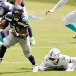 MIAMI GARDENS, FLORIDA - OCTOBER 04: DeeJay Dallas #31 of the Seattle Seahawks breaks a tackle from Jerome Baker #55 of the Miami Dolphins during the first half at Hard Rock Stadium on October 04, 2020 in Miami Gardens, Florida. (Photo by Michael Reaves/Getty Images)