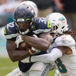 MIAMI GARDENS, FLORIDA - OCTOBER 04: Chris Carson #32 of the Seattle Seahawks runs with the ball against Bobby McCain #28 of the Miami Dolphins during the second half at Hard Rock Stadium on October 04, 2020 in Miami Gardens, Florida. (Photo by Michael Reaves/Getty Images)