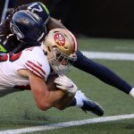 SEATTLE, WASHINGTON - NOVEMBER 01: Ross Dwelley #82 of the San Francisco 49ers scores a touchdown against Tre Flowers #21 of the Seattle Seahawks in the fourth quarter of the game at CenturyLink Field on November 01, 2020 in Seattle, Washington. (Photo by Abbie Parr/Getty Images)