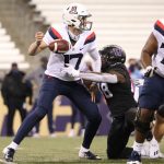 SEATTLE, WASHINGTON - NOVEMBER 21: Grant Gunnell #17 of the Arizona Wildcats fumbles the ball while being hit by Edefuan Ulofoshio #48 of the Washington Huskies in the first quarter at Husky Stadium on November 21, 2020 in Seattle, Washington. (Photo by Abbie Parr/Getty Images)