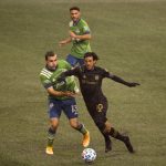 SEATTLE, WASHINGTON - NOVEMBER 24: Jordan Morris #13 of Seattle Sounders and Carlos Vela #10 of Los Angeles FC battle for possession in the first half during Round One of the MLS Cup Playoffs at Lumen Field Field on November 24, 2020 in Seattle, Washington. (Photo by Abbie Parr/Getty Images)
