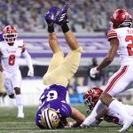 SEATTLE, WASHINGTON - NOVEMBER 28: Cade Otton #87 of the Washington Huskies is tackled by Vonte Davis #19 of the Utah Utes in the third quarter at Husky Stadium on November 28, 2020 in Seattle, Washington. (Photo by Abbie Parr/Getty Images)