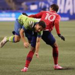SEATTLE, WASHINGTON - DECEMBER 01: Cristian Roldan #7 of Seattle Sounders and Andres Ricaurte #10 of FC Dallas collide in the first half during their Western Conference Semifinal game at Lumen Field on December 01, 2020 in Seattle, Washington. (Photo by Abbie Parr/Getty Images)