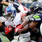 SEATTLE, WASHINGTON - DECEMBER 06: Dion Lewis #33 of the New York Giants is tackled by Jordyn Brooks #56 of the Seattle Seahawks during the second quarter at Lumen Field on December 06, 2020 in Seattle, Washington. (Photo by Abbie Parr/Getty Images)