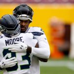 LANDOVER, MARYLAND - DECEMBER 20: DK Metcalf #14 hugs teammate wide receiver David Moore #83 of the Seattle Seahawks before the start of their game against the Washington Football Team at FedExField on December 20, 2020 in Landover, Maryland. (Photo by Tim Nwachukwu/Getty Images)