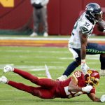 LANDOVER, MARYLAND - DECEMBER 20: Running back Chris Carson #32 of the Seattle Seahawks jumps over cornerback Kendall Fuller #29 of the Washington Football Team in the second half at FedExField on December 20, 2020 in Landover, Maryland. (Photo by Patrick Smith/Getty Images)