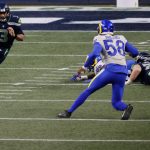 SEATTLE, WASHINGTON - JANUARY 09: Quarterback Russell Wilson #3 of the Seattle Seahawks scrambles against linebacker Justin Hollins #58 of the Los Angeles Rams during the the NFC Wild Card Playoff game  at Lumen Field on January 09, 2021 in Seattle, Washington. (Photo by Steph Chambers/Getty Images)