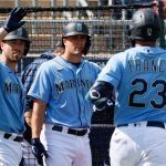 PEORIA, ARIZONA - MARCH 04: Tom Murphy #2, Evan White #12 and Ty France #23 of the Seattle Mariners celebrate after a home run against the Colorado Rockies in the third inning of an MLB spring training game at Peoria Sports Complex on March 04, 2021 in Peoria, Arizona. (Photo by Steph Chambers/Getty Images)