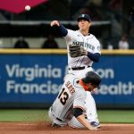 SEATTLE, WASHINGTON - APRIL 01: Dylan Moore #25 of the Seattle Mariners throws over Austin Slater #13 of the San Francisco Giants for a double play in the first inning on Opening Day at T-Mobile Park on April 01, 2021 in Seattle, Washington. (Photo by Steph Chambers/Getty Images)