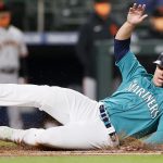 SEATTLE, WASHINGTON - APRIL 02: Ty France #23 of the Seattle Mariners slides safely home against the San Francisco Giants in the third inning at T-Mobile Park on April 02, 2021 in Seattle, Washington. (Photo by Steph Chambers/Getty Images)