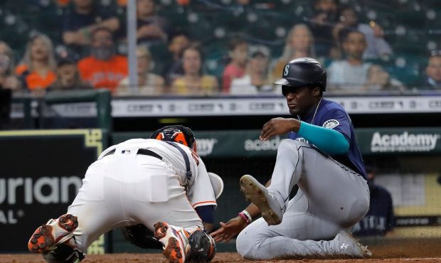 HOUSTON, TEXAS - APRIL 28: Taylor Trammell #20 of the Seattle Mariners slides safely into home base...