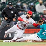 SEATTLE, WASHINGTON - APRIL 30: Anthony Rendon #6 of the Los Angeles Angels cannot catch a errant throw to third base as Dylan Moore #25 of the Seattle Mariners steals in the sixth inning at T-Mobile Park on April 30, 2021 in Seattle, Washington. (Photo by Steph Chambers/Getty Images)