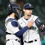 SEATTLE, WASHINGTON - MAY 04: Luis Torrens #22 and Robert Dugger #30 of the Seattle Mariners celebrate after defeating the Baltimore Orioles 5-2 at T-Mobile Park on May 04, 2021 in Seattle, Washington. (Photo by Steph Chambers/Getty Images)