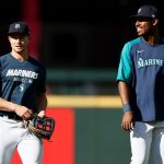 SEATTLE, WASHINGTON - MAY 13: Jarred Kelenic #10 and Kyle Lewis #1 of the Seattle Mariners walk back to the dugout after warming up before the game against the Cleveland Indians at T-Mobile Park on May 13, 2021 in Seattle, Washington. (Photo by Steph Chambers/Getty Images)