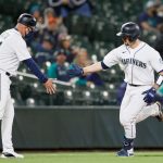 SEATTLE, WASHINGTON - MAY 17: Third base coach Manny Acta #14 high fives Tom Murphy #2 of the Seattle Mariners after Murphy's home run during the eighth inning against the Detroit Tigers at T-Mobile Park on May 17, 2021 in Seattle, Washington. (Photo by Steph Chambers/Getty Images)