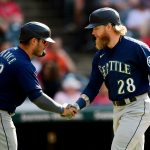 CLEVELAND, OHIO - JUNE 12: Jake Fraley #28 of the Seattle Mariners shakes hands with with Ty France #23 after hitting a two-run home run in the third inning during their game against the Cleveland Indians at Progressive Field on June 12, 2021 in Cleveland, Ohio. (Photo by Emilee Chinn/Getty Images)