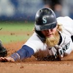 SEATTLE, WASHINGTON - JUNE 14: Jake Fraley #28 of the Seattle Mariners eludes a tag by Miguel Sano #22 of the Minnesota Twins during the third inning at T-Mobile Park on June 14, 2021 in Seattle, Washington. (Photo by Steph Chambers/Getty Images)