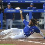BUFFALO, NEW YORK - JUNE 29: Vladimir Guerrero Jr. #27 of the Toronto Blue Jays slides across the plate as he scores on a sacrifice fly by Cavan Biggio during the fifth inning against the Seattle Mariners at Sahlen Field on June 29, 2021 in Buffalo, New York. (Photo by Joshua Bessex/Getty Images)