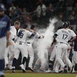 Seattle Mariners' Kyle Seager, center, is covered in powder by teammates after after he drove in the winning run with a single in the ninth inning of the team's baseball game against the Tampa Bay Rays, Thursday, June 17, 2021, in Seattle. Rays' Brandon Lowe, foreground left, heads off the field. The Mariners won 6-5. AP Photo/Ted S. Warren)