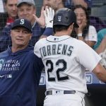 Seattle Mariners manager Scott Servais, left, greets Luis Torrens after Torrens hit a solo home run against the Tampa Bay Rays during the fifth inning of a baseball game Thursday, June 17, 2021, in Seattle. (AP Photo/Ted S. Warren)