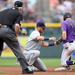 DENVER, COLORADO - JULY 20: Dylan Moore #25 of the Seattle Mariners tags out Garrett Hampson #1 of the Colorado Rockies trying to steal second base in the first inning at Coors Field on July 20, 2021 in Denver, Colorado. (Photo by Matthew Stockman/Getty Images)