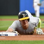 SEATTLE, WASHINGTON - JULY 22: Mark Canha #20 of the Oakland Athletics dives for first base during the fifth inning of the game against the Seattle Mariners at T-Mobile Park on July 22, 2021 in Seattle, Washington. (Photo by Alika Jenner/Getty Images)