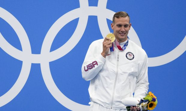 Caeleb Dressel, of the United States, poses with the gold medal after winning the men's 100-meter f...