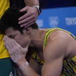 
              Arthur Mariano, of Brazil, is consoled by his coach during men's artistic gymnastic qualifications at the 2020 Summer Olympics, Saturday, July 24, 2021, in Tokyo. (AP Photo/Gregory Bull)
            