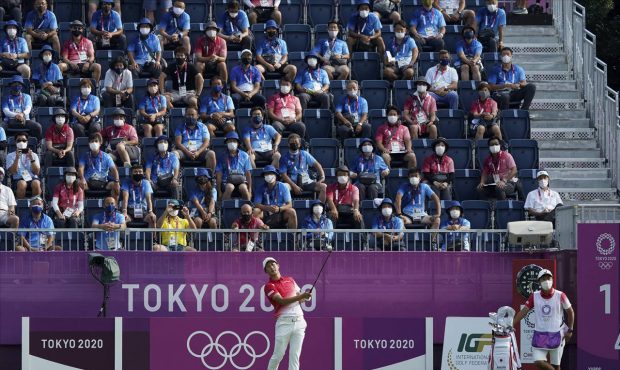 Japan's Rikuya Hoshino watches his tee shot on the first hole during the first round of the men's g...