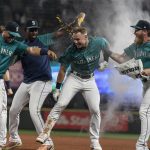 SEATTLE, WA -  AUGUST 13: Jarred Kelenic #10 (C) of the Seattle Mariners celebrates a walk off walk with teammates including Justin Duinn #35 (3L) and Jake Fraley #28 after a game against the Toronto Blue Jays at T-Mobile Park on August 13, 2021 in Seattle, Washington. The Mariners won 3-2. (Photo by Stephen Brashear/Getty Images)