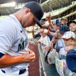 SEATTLE, WASHINGTON - AUGUST 10: Ty France #23 of the Seattle Mariners signs autographs to young fans before the game against the Texas Rangers at T-Mobile Park on August 10, 2021 in Seattle, Washington. (Photo by Alika Jenner/Getty Images)