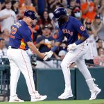 HOUSTON, TEXAS - AUGUST 22: Yordan Alvarez #44 of the Houston Astros receives congratulations from third base coach Omar Lopez #22 after hitting a solo home run in the second inning against the Seattle Mariners at Minute Maid Park on August 22, 2021 in Houston, Texas. (Photo by Bob Levey/Getty Images)