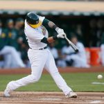 OAKLAND, CALIFORNIA - AUGUST 23: Yan Gomes #23 of the Oakland Athletics hits into an RBI ground out in the bottom of the first inning against the Seattle Mariners at RingCentral Coliseum on August 23, 2021 in Oakland, California. (Photo by Lachlan Cunningham/Getty Images)