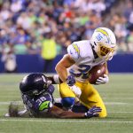 SEATTLE, WASHINGTON - AUGUST 28: Michael Bandy #36 of the Los Angeles Chargers is tackled by Gavin Heslop #38 of the Seattle Seahawks in the third quarter during the NFL preseason game at Lumen Field on August 28, 2021 in Seattle, Washington. (Photo by Abbie Parr/Getty Images)