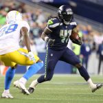 SEATTLE, WASHINGTON - AUGUST 28: Alex Collins #41 of the Seattle Seahawks carries the ball against Brandon Facyson #28 of the Los Angeles Chargers in the third quarter during the NFL preseason game at Lumen Field on August 28, 2021 in Seattle, Washington. (Photo by Abbie Parr/Getty Images)