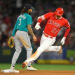 ANAHEIM, CA - SEPTEMBER 25:  J.P. Crawford #3 of the Seattle Mariners looks toward first as Shohei Ohtani #17 of the Los Angeles Angels rounds second base on a triple in the third inning at Angel Stadium of Anaheim on September 25, 2021 in Anaheim, California. (Photo by John McCoy/Getty Images)