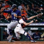 HOUSTON, TEXAS - SEPTEMBER 07: Abraham Toro #13 of the Seattle Mariners scores in the ninth inning as the ball skips away from Garrett Stubbs #11 of the Houston Astros at Minute Maid Park on September 07, 2021 in Houston, Texas. (Photo by Bob Levey/Getty Images)