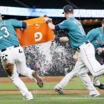 SEATTLE, WASHINGTON - SEPTEMBER 10: Ty France #23 and Mitch Haniger #17 attempt to douse Tom Murphy #2 of the Seattle Mariners with water after beating the Arizona Diamondbacks 5-4 at T-Mobile Park on September 10, 2021 in Seattle, Washington. (Photo by Steph Chambers/Getty Images)