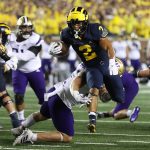 ANN ARBOR, MICHIGAN - SEPTEMBER 11: Blake Corum #2 of the Michigan Wolverines tries to get around the tackle of Ryan Bowman #55 of the Washington Huskies during a first half run at Michigan Stadium on September 11, 2021 in Ann Arbor, Michigan. (Photo by Gregory Shamus/Getty Images)