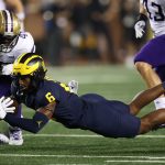 ANN ARBOR, MICHIGAN - SEPTEMBER 11: Cornelius Johnson #6 of the Michigan Wolverines dives for extra yards past Edefuan Ulofoshio #48 of the Washington Huskies after a first half catch at Michigan Stadium on September 11, 2021 in Ann Arbor, Michigan. (Photo by Gregory Shamus/Getty Images)