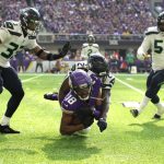 MINNEAPOLIS, MINNESOTA - SEPTEMBER 26: Justin Jefferson #18 of the Minnesota Vikings catches the ball for a first down and is tackled by Tre Flowers #21 of the Seattle Seahawks during the first quarter in the game at U.S. Bank Stadium on September 26, 2021 in Minneapolis, Minnesota. (Photo by David Berding/Getty Images)