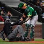 SEATTLE, WASHINGTON - SEPTEMBER 29: Yan Gomes #23 of the Oakland Athletics helps up home plate umpire CB Bucknor #54 after he takes a foul tip to the face during the fifth inning at T-Mobile Park on September 29, 2021 in Seattle, Washington. (Photo by Alika Jenner/Getty Images)