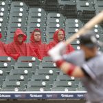 
              Fans watch Chicago White Sox's Yasmani Grandal bat as rain falls during the third inning of a baseball game against the Detroit Tigers on Tuesday, Sept. 21, 2021, in Detroit. (AP Photo/Duane Burleson)
            