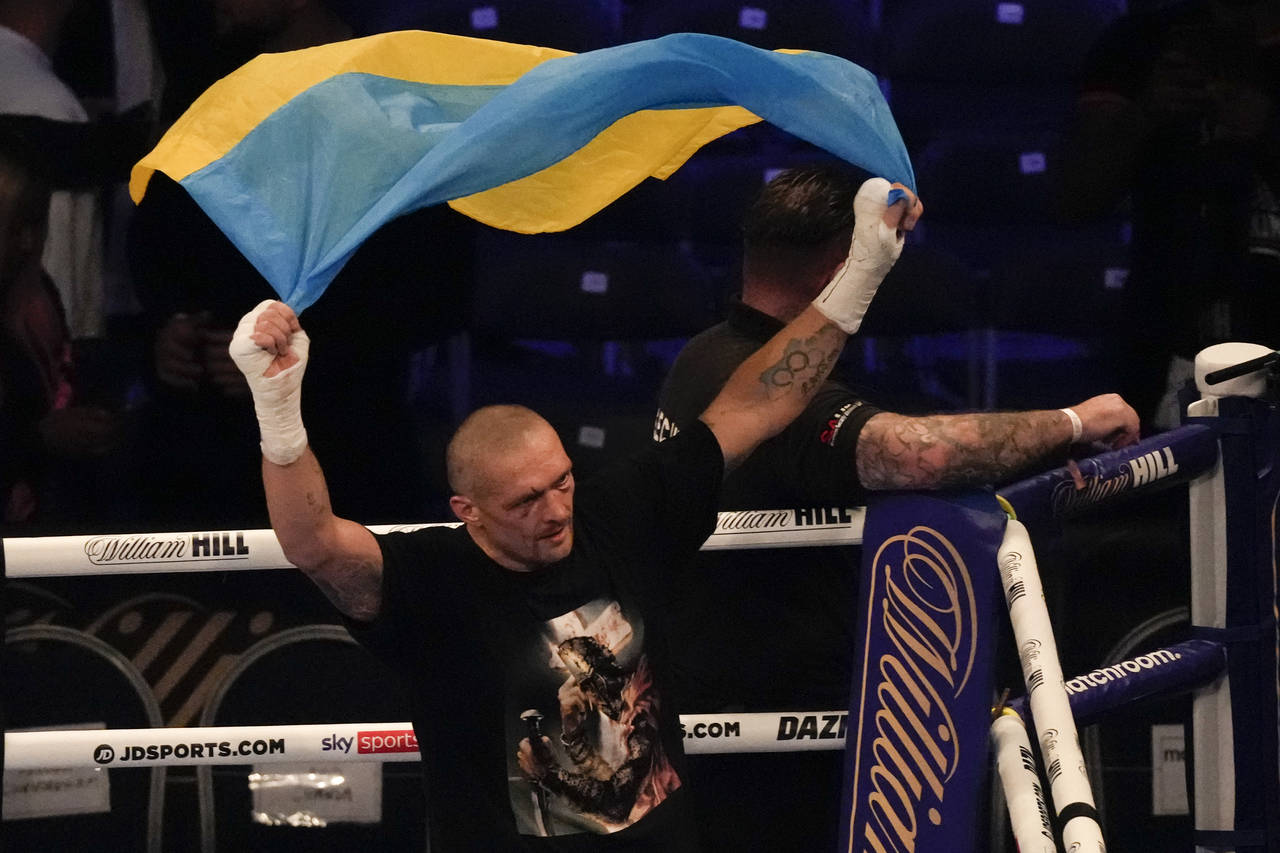 Oleksandr Usyk of Ukraine holds up the Ukrainian flag after his unanimous decision victory over Ant...