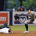 
              Miami Marlins' Jazz Chisholm Jr. (2) advances to second base on an error on a pickoff throw to first as Pittsburgh Pirates shortstop Kevin Newman (27) waits for the throw during the first inning of a baseball game, Saturday, Sept. 18, 2021, in Miami. (AP Photo/Marta Lavandier)
            