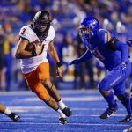 
              Oklahoma State quarterback Spencer Sanders (3) runs with the ball past Boise State defensive end Demitri Washington (38) during the first half of an NCAA college football game Saturday, Sept. 18, 2021, in Boise, Idaho. (AP Photo/Steve Conner)
            
