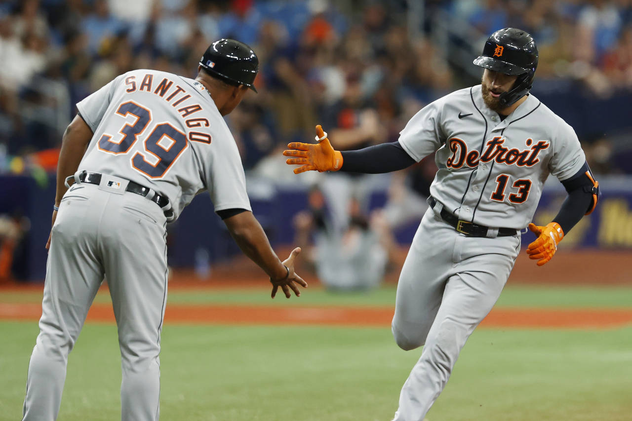 Detroit Tigers' Eric Haase (13) celebrates with third base coach Ramon Santiago after hitting a hom...