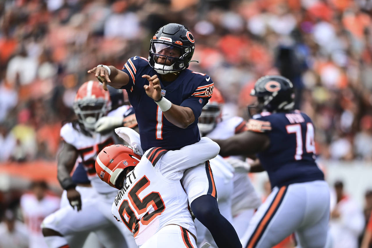Chicago Bears quarterback Justin Fields (1) is hit by Chicago Bears defensive tackle Khyiris Tonga ...