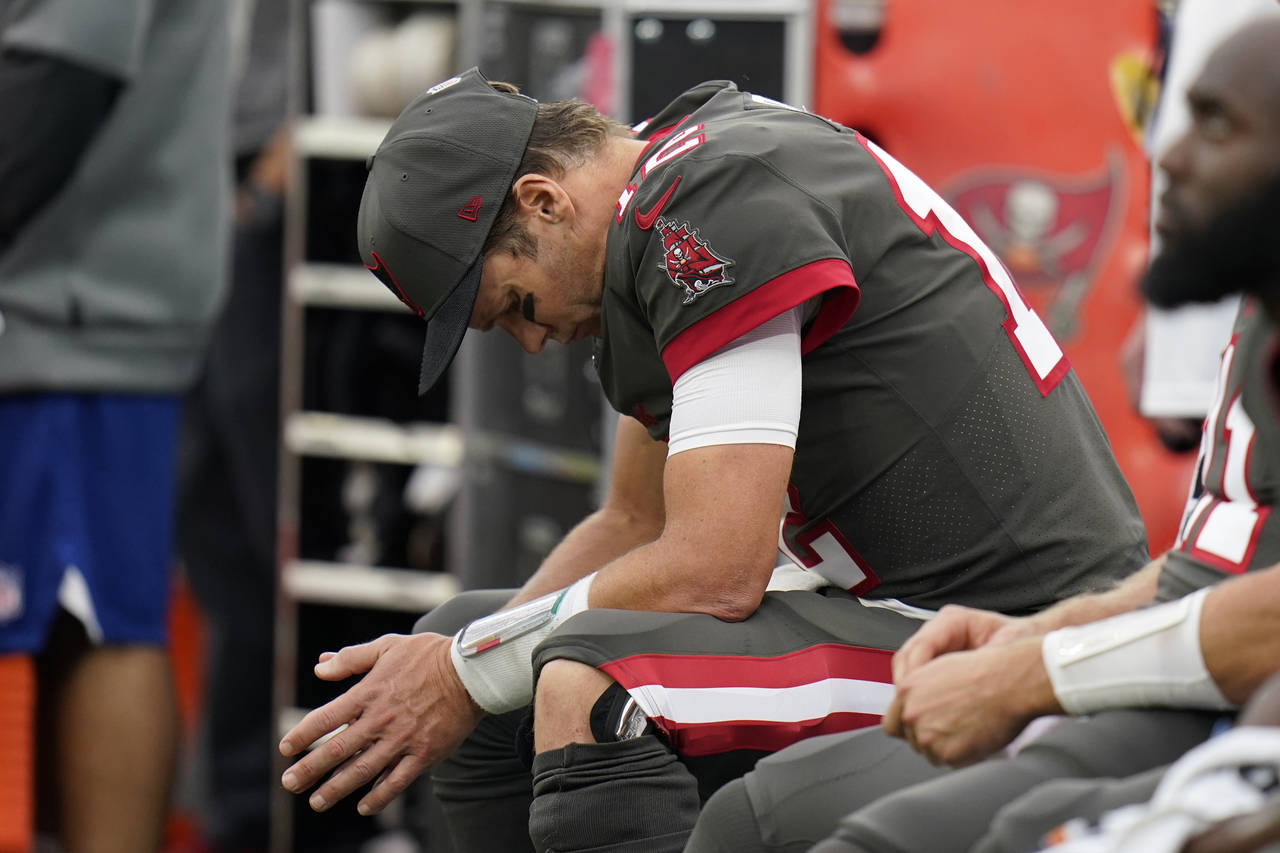 Tampa Bay Buccaneers quarterback Tom Brady looks down as he sits on the bench during the second hal...